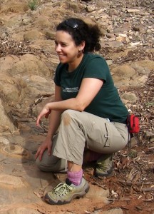Phoebe Cohen kneeling on some stromatolites in Australia, working on a 'virtual field trip' on the evolution of complex life. (Photo courtesy of Phoebe Cohen)