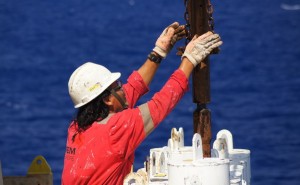 Bosun Leo Yaun stores the core barrels back on board once we finished drilling.  Credit: Amy West
