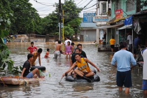 Residents of Manila, in the Philippines, wade through flooded streets after severe storms caused the Marikina River to overflow in 2012. Increased urbanization in the Philippines, seen in satellite images as more abundant nightlights, preceded several economically catastrophic floods in the region in recent years.  Credit: Department of Foreign Affairs and Trade