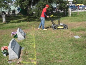 A graduate student pushes a ground-penetrating radar device along gridlines marked in Mueschke Cemetery. Credit: Azie Aziz