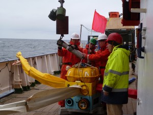 Scientists deploy an ocean bottom electric field sensor on a wire aboard the RV Meteor in May 2012.  Credit: Wu-Cheng Chi. 