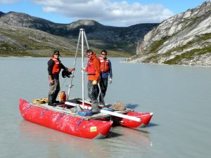 Members of the research team collect lake sediment cores from a coring platform in Western Greenland. Credit: Jason Briner. 
