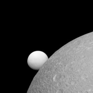 Although Dione (near) and Enceladus (far) are composed of nearly the same materials, Enceladus endures a constant rain of ice grains from its south polar jets. As a result, Enceladus’ surface is much brighter, but the interiors of the two moons could look alike, according to new research. Credit: NASA/JPL-Caltech/Space Science Institute. 