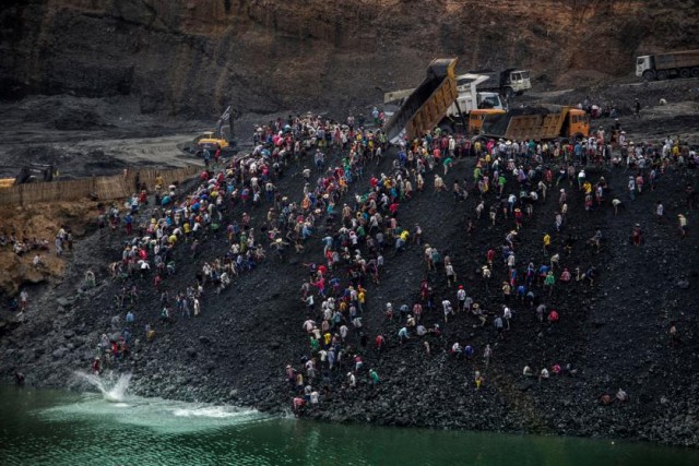 Small-scale miners search for stone as dump trucks from Myanmar Sein Lei Aung mining company dump waste in Hmaw Si Zar, Lone Khin, Hpakant, April 2015. These dumping operations are the major cuase of the Burma jade mine landslides. From Time Maganzine