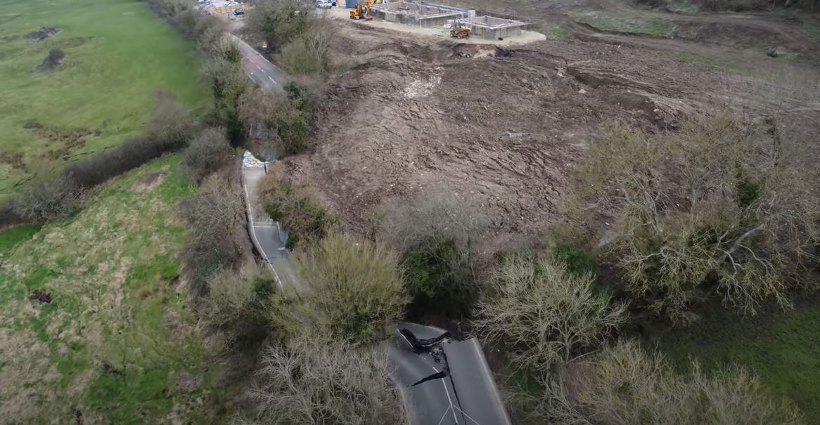 The Lyneham landslide, showing construction activity in the field upslope of the road. Still from a video posted to Youtube.