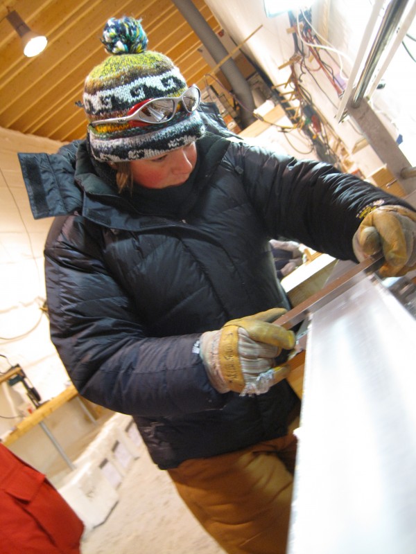 Rosen cleans a section of the the North Greenland Eemian (NEEM) ice core before measuring the electrical conductivity of the ice in August 2009. This photo was taken at the NEEM camp in northern Greenland. Photo courtesy of Julia Rosen.